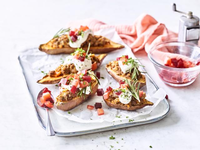 Gepofte zoete aardappel gevuld met gehakt, rode biet en tomaten